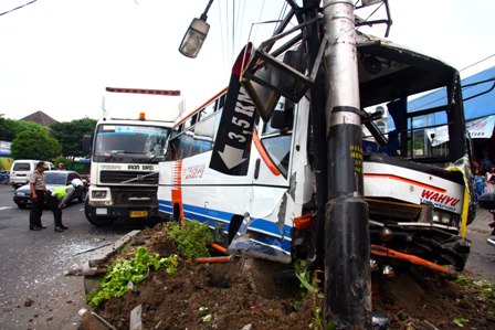 Dwi Prasetya TABRAK BUS- Petugas mengidentifikasi Tempat Kejadian Perkara (TKP) kecelakaan antara truk trailer Nopol B 9189 QZ dengan bus Wahyu Nopol AD 1630 AB di ruas Jl Kol Suratto 150 Solo, Kamis (6/1). Akibat kecelakaan tersebut sembilan penumpang bus mengalami luka-luka.