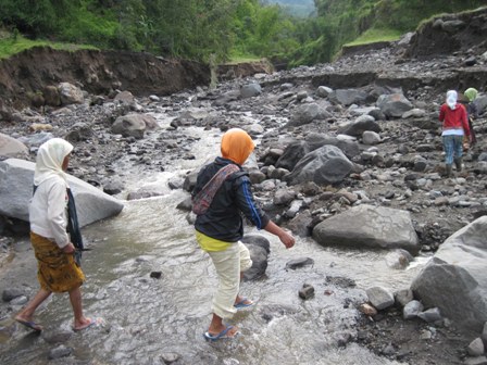 MENYEBERANG SUNGAI—Sejumlah warga Dukuh Bangunsari, Desa Klakah terpaksa menyeberangi sungai di aliran Kali Juweh, setelah jembatan Bangunsari terputus akibat diterjang banjir lahar dingin Merapi. Foto diambil Rabu (12/1). (FOTO: Espos/Ahmad Mufid Aryono)