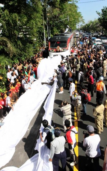TARIK SELUBUNG -- Petugas bersama para anggota kuomunitas penggemar kereta beramai-ramai menarik selubung railbus setelah sarana angkutan umum massal itu diresmikan oleh Menteri Perhubungan Freddy Numberi di depan rumah dinas Walikota Solo, Loji Gandrung, Selasa (26/7/2011). (JIBI/SOLOPOS/Sunaryo Haryo Bayu)