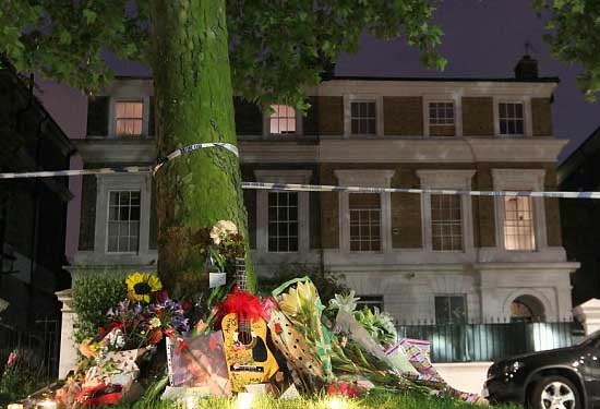 KENANGAN -- Fans yang berduka meletakkan bunga dan bahkan sebuah gitar sebagai tanda belasungkawa di depan rumah Amy Winehouse. (Dailymail.co.uk)