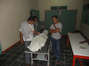 PERIKSA JENAZAH--Anggota Satreskrim Polres Grobogan mengecek identitas korban tewas pesta miras, Rohmin, 42, warga Klambu, Grobogan, di kamar jenazah sebelum dilakukan otopsi, Kamis (29/3) malam hinga Jumat (30/3/2012) dini hari di RSD dr R Soedjati Purwodadi. (Arif Fajar S/JIBI/SOLOPOS)