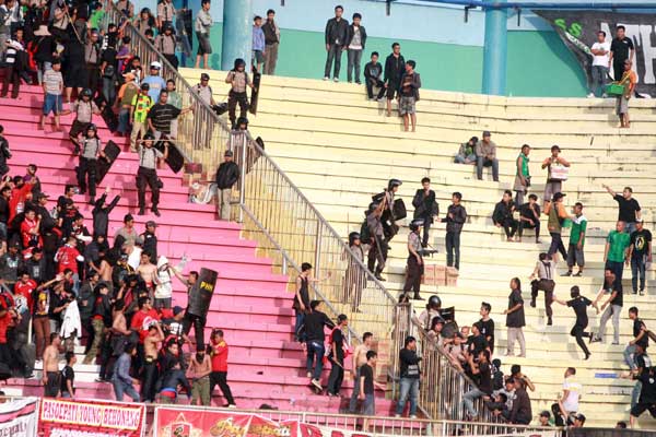 PANAS -- Petugas kepolisian mencoba melerai para suporter yang terlibat bentrok di tribun Stadion Maguwo harjo Selaman dalam pertandingan Persis Solo melawan PSS Sleman, Sabtu (21/4/2012). (JIBI/Harian Jogja/Gigih M Hanafi)