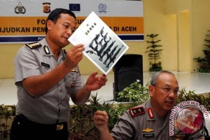 Kabid Humas Polda Aceh, Kombes Pol Gustav Leo (kiri, memegang gambar senjata) mendampingi Kepala Kepolisian Daerah (Kapolda) Aceh, Irjen Pol Iskandar Hasan (kanan). (Foto Antara)