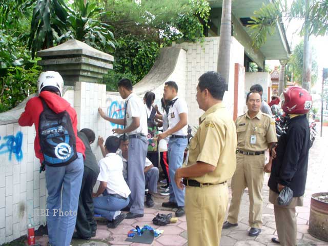 Siswa dari SMK Ganesha Tama dan SMK Muhammadiyah 4 Boyolali kerja bakti membersihkan coretan di depan pintu gerbang Stadion Sono Kridanggo Boyolali. Foto diambil, Selasa (4/12/2012). (JIBI/SOLOPOS/Mahardini Nur Afifah)