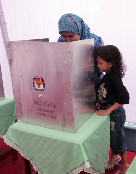 Seorang anak mengintip ibunya yang melakukan pencoblosan di bilik suara pada pemilihan kepala daerah Sulawesi Selatan priode 2013-2018 di TPS 01 Makassar, Selasa (22/1/2013). Pilkada tersebut diikuti tiga calon yakni Syarul Yasin Limpo (incumbent), Ilham Arief Sirajuddin, dan Rudiyanto Asapa yang diikuti 6.283.811 wajib pilih. (JIBI/Bisnis/Paulus Tandi Bone)