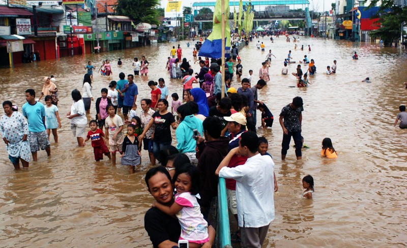 Warga sekitar Bukit Duri keluar rumah untuk menyaksikan banjir yang menggenangi Jalan Raya di Jakarta, Rabu(16/1