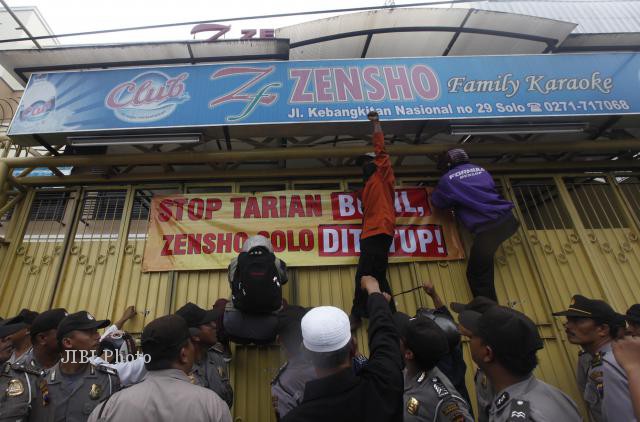 (JIBI/SOLOPOS/Agoes Rudianto)
Anggota Laskar Umat Islam Surakarta (LUIS) memasang spanduk di pagar tempat karaoke Zensho, Sriwedari, Solo, Rabu (16/1/2013). Mereka meminta tempat karaoke itu ditutup karena menurut mereka digunakan untuk atraksi tarian telanjang.