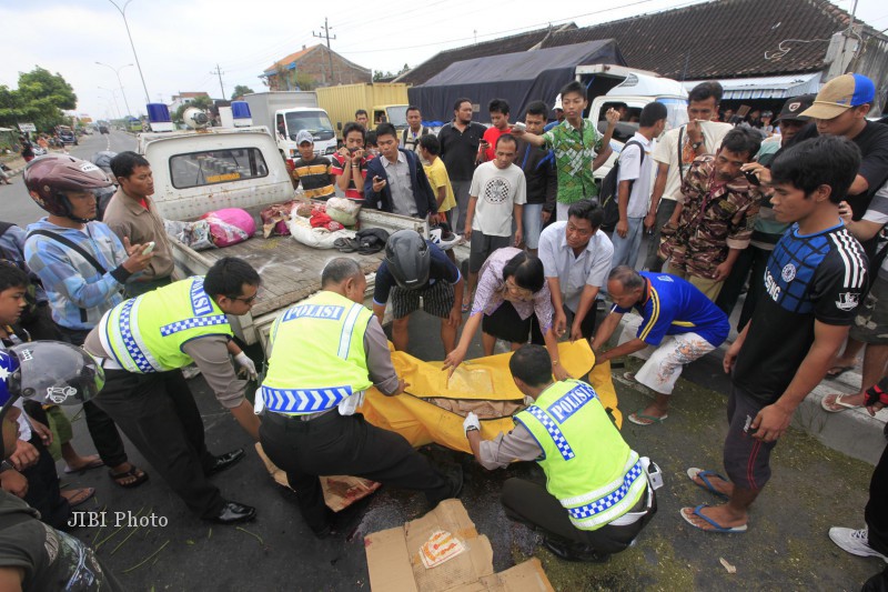 Polisi dibantu warga mengevakuasi jenazah Mulyani, warga Mojosongo, Boyolali yang menjadi korban kecelakaan di pertigaan Ngemplak, Kartasura, Rabu (20/2/2013). (JIBI/SOLOPOS/Agoes Rudianto)