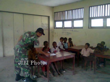 Seorang personel Yonif 408/Suhbrastha tengah mengajar anak-anak di sebuah sekolah di Papua, sebagai salah satu tugas pengabdian masyarakat di samping melaksanakan tugas utama melakukan pengamanan perbatasan Indonesia-Papua Nugini. (yonif-408-suhbrastha.blogspot.com)