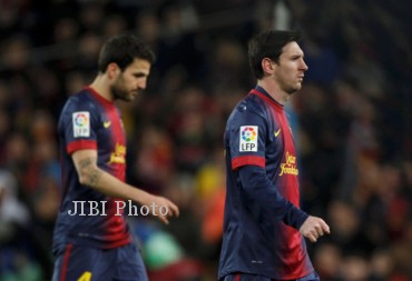 Barcelona's Lionel Messi (R) and Cesc Fabregas leaves the pitch after their Spanish King's Cup semifinal second round soccer match against Real Madrid at Camp Nou stadium in Barcelona February 26, 2013. REUTERS/Gustau Nacarino (SPAIN - Tags: SPORT SOCCER)