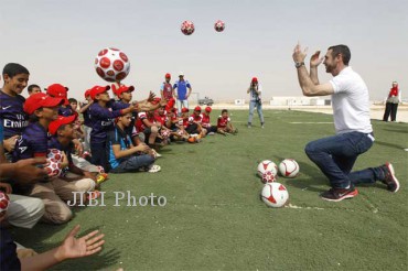 Martin Keown (kanan), mantan pemain Arsenal, memandu acara bersama anak-anak pengungsi Suriah dalam acara pembukaan lapangan sepakbola yang merupakan prakarsa program  Save the Children di kamp pengungsi Al Zaatri, Mafraq, Jordania, belum lama ini. Badan pengungsi PBB, UNHCR mencatat saat ini jumlah pengungsi Surioah di luar negeri sudah mencapai 1,5 juta jiwa. (JIBI/SOLOPOS/Reuters)