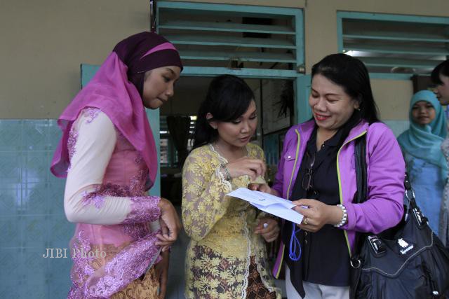 Siswa SMA N 5 Solo melihat surat keterangan kelulusan yang dibawa wali muridnya saat pengumuman hasil Ujian Nasional 2013 di sekolah setempat, Jumat, (24/5/2013). (JIBI/SOLOPOS/Maulana Surya)
