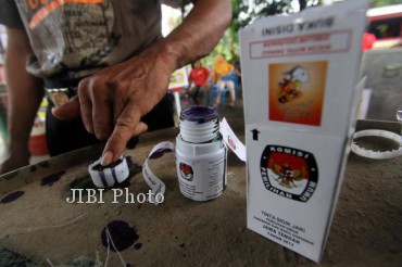 Pemilih mencelupkan jarinya ke tinta sebagai tanda telah memberikan suaranya di TPS 85 Kadipiro, Solo, Minggu (26/5/2013). (JIBI/SOLOPOS/Burhan Aris Nugraha)