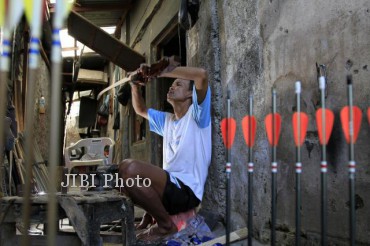  Pengrajin panahan menyelesaikan pembuatan busur panah tradisional di ruang produksinya di Dawung Wetan, Danukusuman, Solo , Kamis (18/7). Alat panah tradisonal untuk kebutuhan atlet panahan ini dijual dengan harga Rp. 1,5 juta hingga Rp. 3 juta, tergantung jenis bahan yang digunakan. 