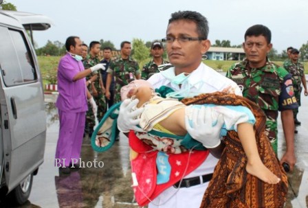 Petugas medis menggendong seorang bocah korban gempa di Aceh Tengah, Selasa (2/7/2013). Bocah itu, Rabu (3/7/2013), dievakuasi dengan pesawat untuk dirujuk ke Rumah Sakit Zainal Abidin, Banda Aceh. (JIBI/Solopos/Antara/Ampelsa)