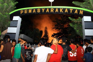 Warga menyaksikan kebakaran Lembaga Pemasyarakatan Kelas I Tanjung Gusta akibat kerusuhan oleh sejumlah napi di Medan, Sumut, Kamis malam (11/8). Padamnya listik dan pasokan air tersebut diduga menjadi pemicu kerusuhan dan kaburnya para tahanan.