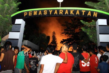 Warga menyaksikan kebakaran Lembaga Pemasyarakatan Kelas I Tanjung Gusta akibat kerusuhan oleh sejumlah napi di Medan, Sumut, Kamis malam (11/8). Padamnya listik dan pasokan air tersebut diduga menjadi pemicu kerusuhan dan kaburnya para tahanan. 