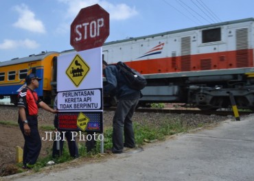 Petugas Dinas Perhubungan, Komunikasi dan Informatika (Dishubkominfo) Karanganyar memasang rambu-rambu lalu lintas portable di perlintasan Kereta Api (KA) tanpa palang pintu di Desa Pulosari, Kecamatan Kebakkramat, Jumat (26/7/2013).