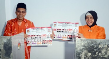 Calon Walikota Makassar Moh. Ramdhan "Danny" Pomanto (kiri) bersama istri Indira Jusuf Ismail (kanan) menunjukan kertas suara saat melakukan pemungutan suara di TPS 12 Kelurahan Maricayya, Makassar, Sulsel, Rabu (18/9/2013). (JIBI/SOLOPOS/Antara)