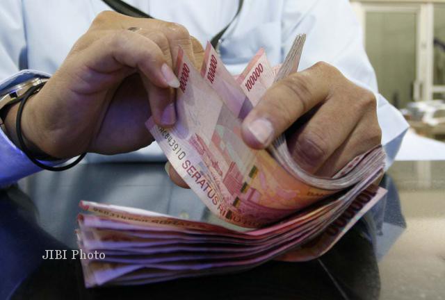 Ilustrasi menghitung uang pecahan Rp100.000 (Dok/JIBI/Bisnis)