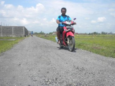 Espos/Iskandar Salah seorang warga melintas di jalan desa Ngabeyan, Kecamatan Kartasura, Sukoharjo, Selasa (3/12/2013) yang baru saja dibangun.(Iskandar/JIBI/Solopos)