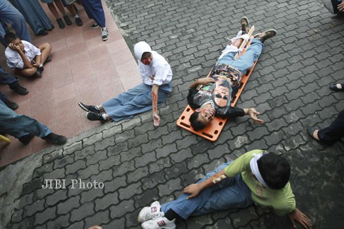 Sejumlah siswa yang menjadi korban gempa bumi menanti tim medis saat diselenggarakan pelatihan dan simulasi penanganan korban gempa bumi yang digelar oleh Badan Penanggulangan Bencana Daerah (BPBD) DIY di SLB Negeri 2 Jogja, Selasa (24/12/2013). Simulasi itu juga menekankan pada kemampuan para guru untuk memberikan pertolongan pertama sebelum tim medis datang dan pengurangan resiko bencana dikarekanan mereka mengajar untuk siswa SLB C yang menyandang tunagrahita dengan keterbelakangan mental. (JIBI/Harian Jogja/Desi Suryanto)