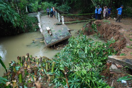 Sejumlah warga mengamati jembatan penghubung antardesa yang putus di Dukuh Serabi Kidul, Getas Serabi, Gebog, Kudus, Jawa Tengah, Rabu (29/1/2014). Akibat jembatan utama yang putus setelah diterjang banjir bandang itu, ratusan warga di kawasan itu harus memutar arah sekitar 3 km jika berpergian. (JIBI/Solopos/Antara/Andreas Fitri Atmoko)
