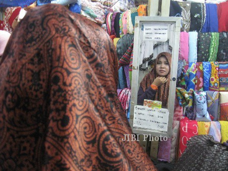 Calon pembeli sedang mencoba memakai kerudung Angel Lelga di salah satu kios yang menjual aneka kerudung, NR di Los E1-19 Pasar Klewer sebelah barat, Selasa (25/2/2014).(JIBI/Solopos/Sri Sumi Handayani)
