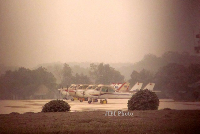 Pesawat latih TNI AU di atas landasan yang tertutup abu vulkanik. (Adib Muttaqin Asfar/JIBI/Solopos)