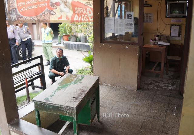 Petugas Polresta Solo melakukan pemeriksaan terhadap pos Linmas di halaman Kalurahan Sriwedari, Jl Kebangkitan Nasional, Solo, Senin (24/2). Sebelumnya sekelompok massa tak dikenal telah merusak Zhengzho karaoke dan melempar bom molotov ke pos limnas tersebut Minggu (23/2/2014) malam. (JIBI/Solopos/Sunaryo Haryo Bayu)