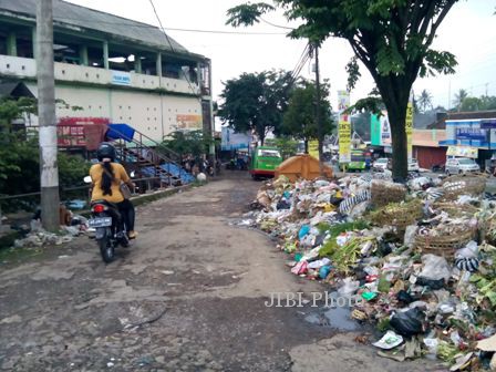 Pengendara melintas jalan keluar Pasar Umum Ampel yang sebagian badan jalan sudah dipenuhi sampah, Kamis (6/2/2014).(JIBI/Solopos/Hijriyah Al Wakhidah)