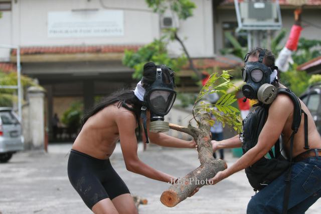 Suryadi Sali bersama Tony Brur, mahasiswa Pascsarjana ISI Yogyakarta menggelar aksi teatrikal sabagai wujud keprihatinan mereka atas ditebangnya 18 pohon peneduh di sepanjang jalan menuju kampus Pascasarjana ISI Yogyakarta, di Suryodiningratan, Yogyakarta, Senin (03/03/2014). Pasca ditebangnya pohon-pohon perindang itu warga maupun mahasiswa mengeluh karena jalan dan lingkungan menuju kampus menjadi sangat gersang dan panas. Tidak diketahui siapa pihak yang menebang pohon-pohon tersebut. (Desi Suryanto/JIBI/Harian Jogja)