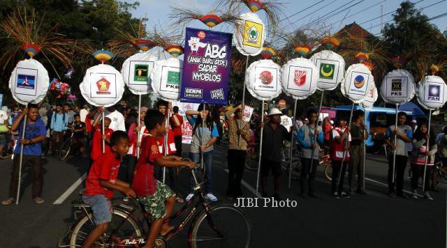 Warga melakukan aksi unjuk rasa dengan membawa poster dan gambar partai politik peserta pemilu di arena Car Free Day Solo, Jl. Slamet Riyadi, Solo, Minggu (9/3/2014). Aksi tersebut bertujuan mengajak pemilih pemula untuk berpartisispasi dalam pemungutan suara Pemilu 9 April 2014 mendatang untuk memilih para anggota lembaga-lembaga legislatif. (Ardiansyah Indra Kumala/JIBI/Solopos)