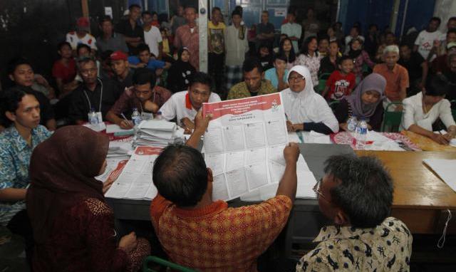 Warga melihat perhitungan surat suara di TPS 82 Semanggi, Pasar Kliwon, Solo, Jawa Tengah, Rabu (9/4/2014). Petugas penyelenggara pemilu akan mulai merekapitulasi perhitungan surat suara itu, Jumat (11/4/2014). Hasil pemungutan suara DPRD kota, DPRD provinsi, DPR, dan DPD tersebut akan diumumkan secara nasional pada 7-9 Mei 2014. (Ardiansyah Indra Kumala/ JIBI/Solopos)