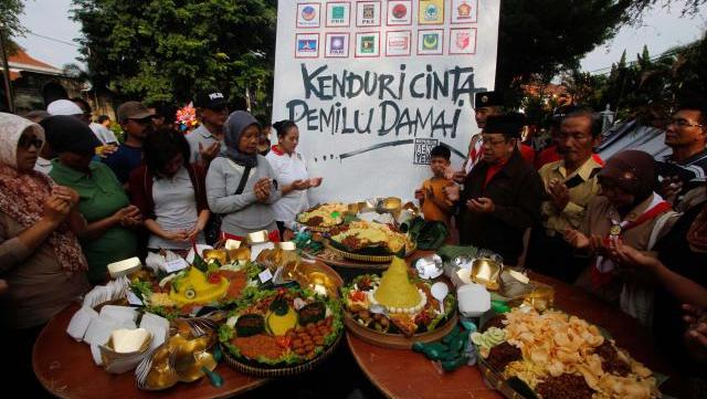 Warga berdoa bersama saat digelar Kenduri Cinta Pemilu Damai arena Car Free Day (CFD) Kota Solo di sepanjang Jl Slamet Riyadi, Solo, Minggu (6/4/2014). Acara tersebut digelar untuk mendoakan kelancaran penyelenggaraan pemungutan suara Pemilu 2014 sehingga berlangsung semarak, aman, dan lancar. (Ardiansyah Indra Kumala/JIBI/Solopos)