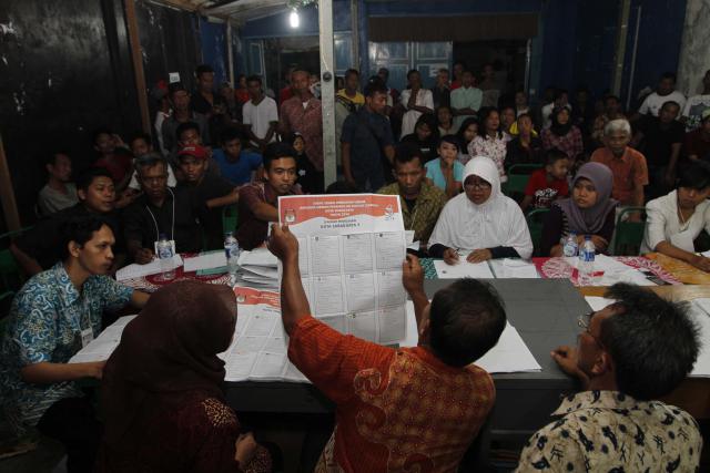 Warga melihat perhitungan surat suara di TPS 82 Semanggi, Pasar Kliwon, Solo, Rabu (9/4/2014). Hasil pemilihan umum DPR, DPRD tingkat 1, DPRD tingkat 2, dan DPD tersebut akan diumumkan secara nasional pada 7-9 Mei 2014. (Ardhiansyah IK/JIBI/Solopos)