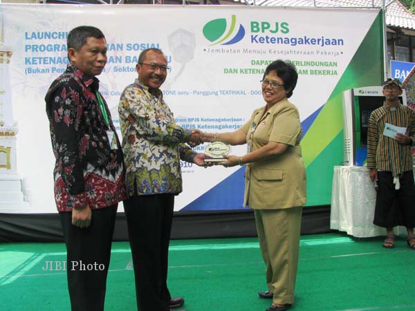 Direktur Kepesertaan dan Hubungan Antar Lembaga, BPJS Ketenagakerjaan, Junaedi (dua dari kiri) memberi kenang-kenangan kepada Asisten Sekda Bidang Administrasi Umum Pekot Jogja, Pontjosiwi (kanan) usai peluncuran Program Jaminan Sosial Ketenagakerjaan bagi sektor informal di kawasan Malioboro, Rabu (10/9/2014). (JIBI/Harian Jogja/Abdul Hamied Razak)