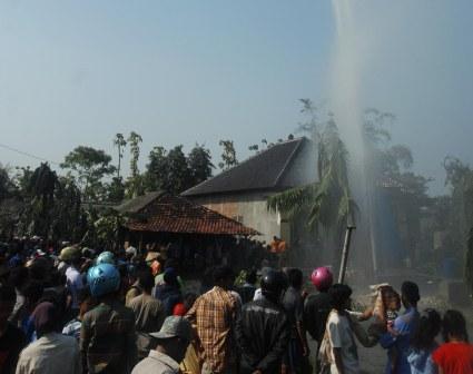 Warga melihat titik semburan air dari sumur bor di Dukuh Sarimulyo, Desa Wotan, Sukolilo, Pati, Jawa Tengah, Minggu (2/11/2014). Semburan air bercampur lumpur serta gas setinggi sekitar 20 meter dari lokasi pengeboran sumur sedalam 160 meter yang terjadi sejak Sabtu (1/11) membuat 70 kepala keluarga (KK) mengungsi. (JIBI/Solopos/Antara/Andreas Fitri Atmoko)