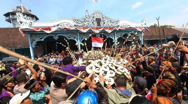 Warga berebut gunungan dalam perayaan Garebeg Syawal di halaman Masjid Agung Solo, Minggu (19/7/2015).