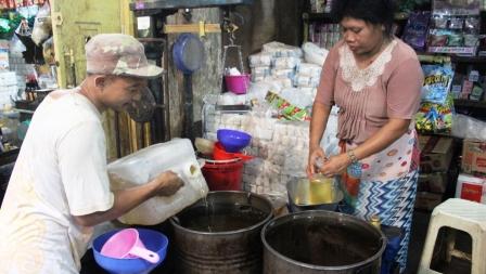 Pedagang menakar minyak curah di Pasar Legi, Rabu (1/7). Sejumlah harga kebutuhan pokok perlahan naik menjelang Lebaran. (Shoqib Angriawan/JIBI/Solopos)