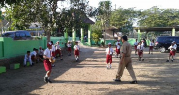 Sudarno, Kepala Sekolah SDN Kradinan 2, meminta siswa bersiap upacara, Senin (7). (Irawan Sapto Adhy/JIBI/Madiunpos.com)