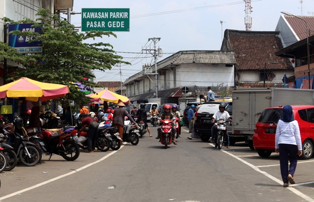 Warga melintasi kawasan parkir di sisi utara Pasar Gede Solo, Senin (18/1/2016). Dishubkominfo Kota Solo merencanakan pembangunan gedung parkir dua lantai di kawasan tersebut untuk menyelesaikan masalah lahan parkir setelah penataan koridor Pasar Gede. (Ivanovich Aldino/JIBI/Solopos)