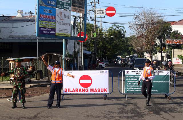 Anggota TNI dan Dishubkominfo Solo, berjaga saat penerapan sistem satu arah pada hari pertama di simpang tiga Purwosari, Laweyan, Solo, Kamis (17/3/2016). Sistem satu arah tersebut diterapkan pada tiga ruas jalan secara serentak di Jl. dr. Radjiman, Jl. KH. Agus Salim, dan Jl. Perintis Kemerdekaan, untuk menekan angka kecelakaan serta meningkatkan minat warga menggunakan angkutan umum massal. (Ivanovic A/JIBI/Solopos)