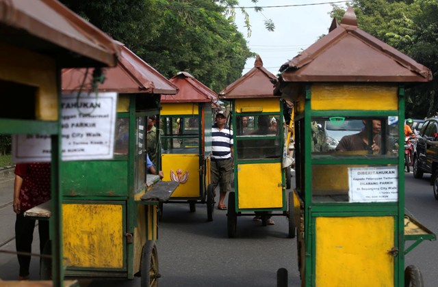 Pedagang kaki lima (PKL) mendorong gerobak saat mengikuti kirab Boyongan PKL Citywalk di Jl. Slamet Riyadi, Solo, Jumat (1/4/2016). Kirab boyongan tersebut diikuti 54 PKL yang direlokasi dari citywalk, Jl. Slamet Riyadi ke kawasan sisi selatan dan timur Stadion Sriwedari. (Ivanovich Aldino/JIBI/Solopos)