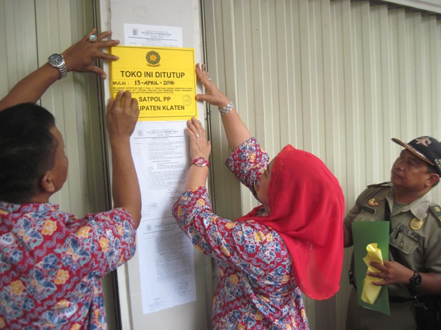 Bupati Klaten, Sri Hartini, menempelkan stiker penutupan toko modern berjejaring yang beroperasi tanpa izin di Jl. Veteran, Bareng Lor, Klaten Utara, Rabu (13/4/2016). (Taufiq Sidik Prakoso/JIBI/Solopos)