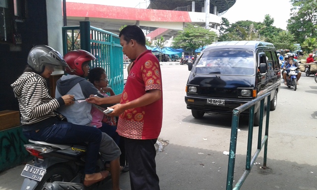 Petugas menarik retribusi parkir di Stadion Manahan, Minggu (10/4/2016). (Irawan Sapto Adhi/JIBI/Solopos)