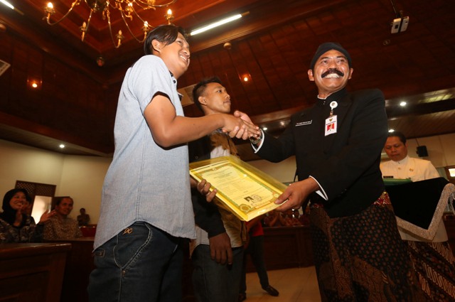 Wali kota Solo, F.X. Hadi Rudyatmo (kanan), memberikan ijazah yang sempat tertahan sekolah kepada siswa lulusan SMK di Balai Tawangarum, kompleks Balai Kota Solo, Kamis (21/4/2016). Pemkot Solo membantu pengeluaran 90 ijazah siswa kurang mampu yang sempat tertahan di SMA atau SMK negeri dan swasta se-Kota Solo. (Ivanovich Aldino/JIBI/Solopos)