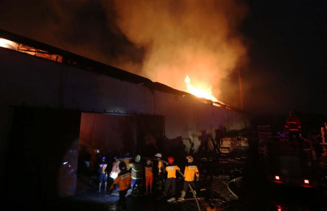 Petugas pemadam kebakaran (Damkar) menyemprotkan air untuk memadamkan api yang membakar gudang pengolahan kayu di pabrik mabel PT. Rakabu Sejahtera, Kalijambe, Sragen, Selasa (19/4/2016). Penyebab kebakaran diduga bersumber dari oven pengering kayu, tidak ada korban jiwa pada kejadian tersebut. Mobil Damkar dari Solo, Sragen, dan Karanganyar dikerahkan untuk memadamkan api. (Ivanovic Aldino/JIBI/Solopos)