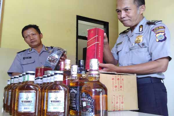 Petugas Polsek Pengasih menunjukkan puluhan botol miras yang diamankan dari warga Dusun Timpang, Desa Sendangsari, Kecamatan Pengasih, Kulonprogo, Jumat (1/4/2016).(Rima Sekarani I.N./JIBI/Harian Jogja)