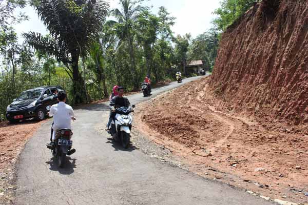 Beberapa warga melewati jalan yang sedang dilebarkan di wilayah Dusun Nglinggo, Desa Pagerharjo, Kecamatan Samigaluh, Kulonprogo, Selasa (19/4). Pelebaran jalan yang dilakukan dengan memapras tebing tersebut merupakan bagian dari program bedah menoreh.(Rima Sekarani I.N./JIBI/Harian Jogja)